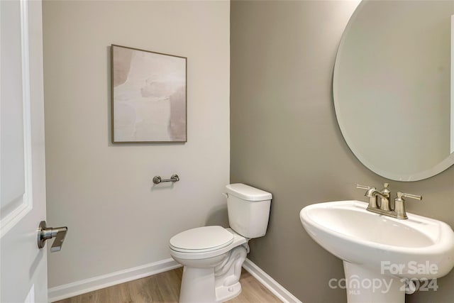 bathroom with toilet, sink, and hardwood / wood-style floors