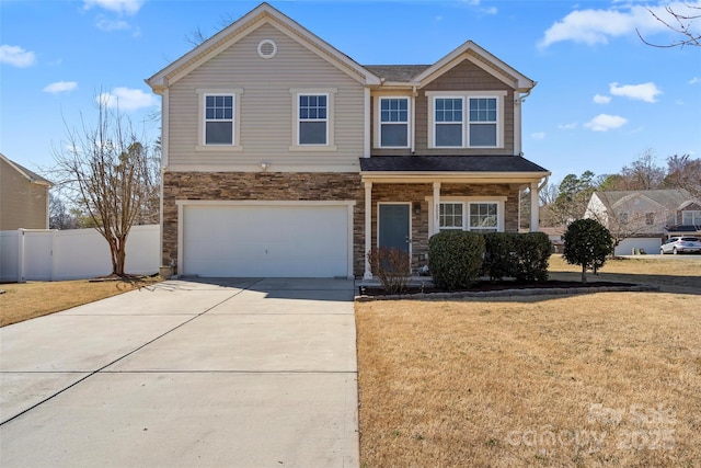 view of front of house with concrete driveway, stone siding, an attached garage, fence, and a front lawn