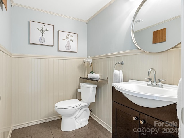 bathroom with tile patterned floors, vanity, toilet, and ornamental molding