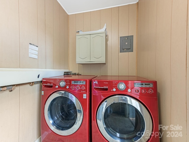 clothes washing area featuring wooden walls and independent washer and dryer