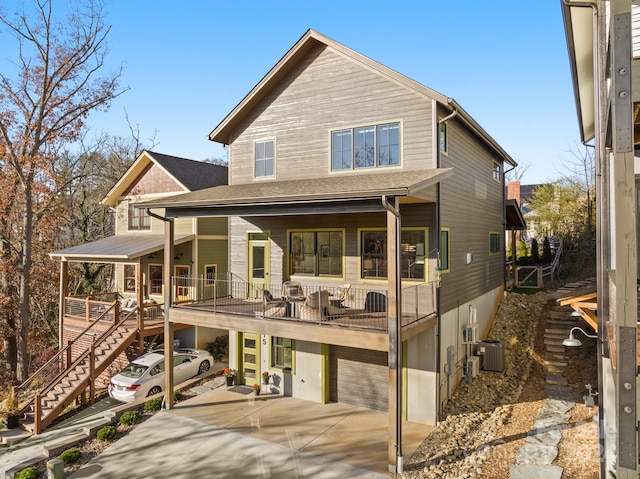 rear view of property featuring a garage and cooling unit