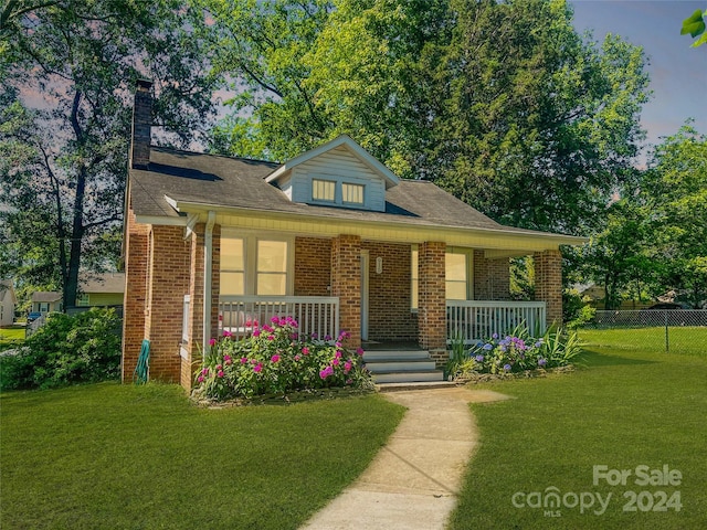 view of front of house with a porch and a front yard