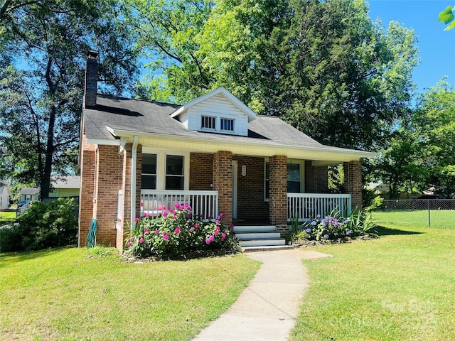 bungalow-style house featuring covered porch, a front lawn, and brick siding