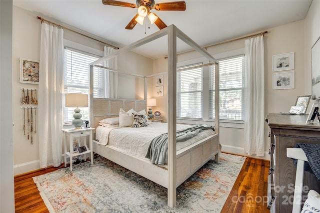 bedroom featuring multiple windows, dark wood-style flooring, and baseboards