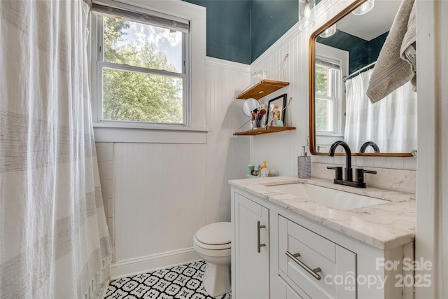 full bathroom with toilet, vanity, and a healthy amount of sunlight