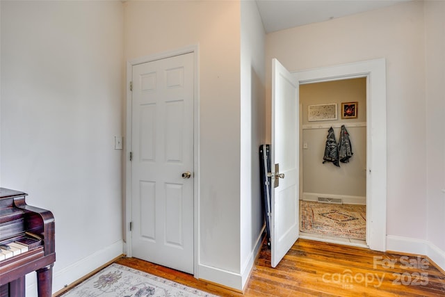 foyer featuring visible vents, baseboards, and wood finished floors