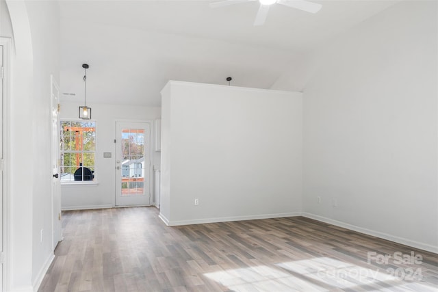 spare room featuring ceiling fan, light wood-type flooring, and lofted ceiling