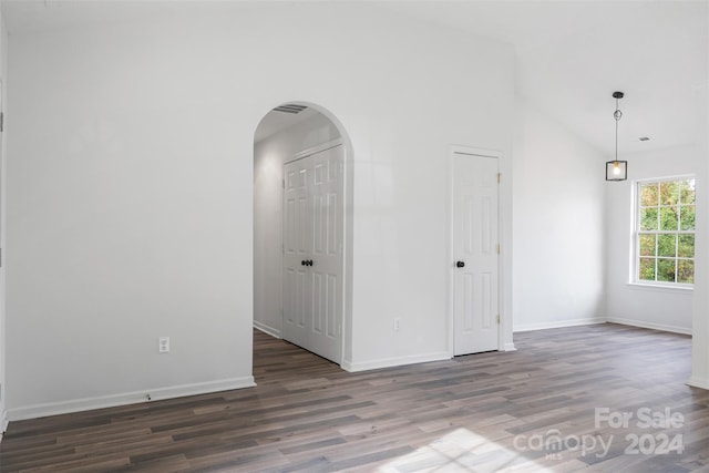 unfurnished room with dark hardwood / wood-style floors and vaulted ceiling