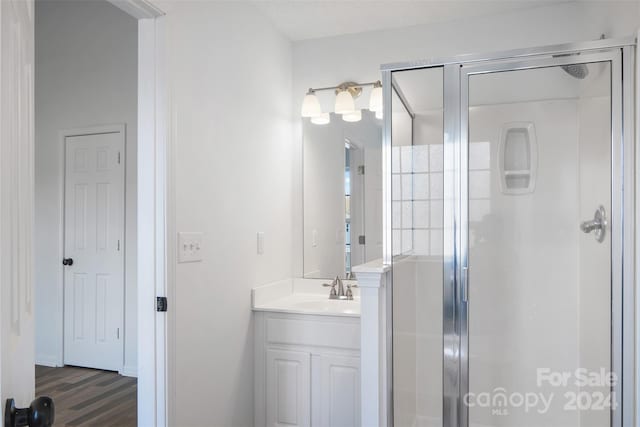 bathroom featuring an enclosed shower, vanity, and wood-type flooring