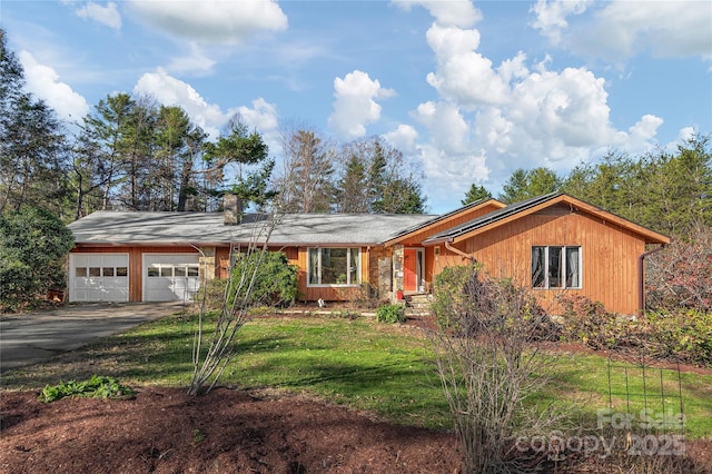 ranch-style home with a garage and a front lawn