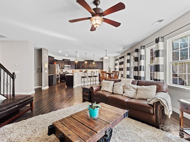 living room with ceiling fan and dark wood-type flooring