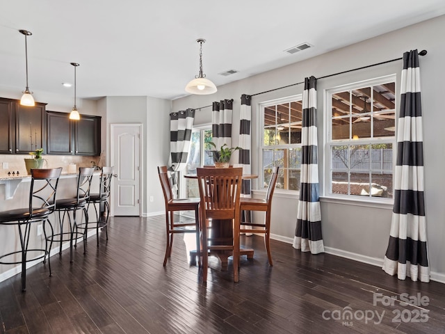 dining area with dark wood-style flooring, visible vents, and baseboards