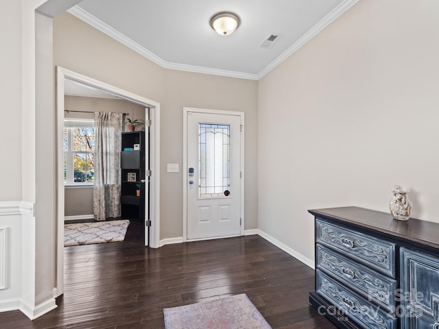 foyer with ornamental molding, hardwood / wood-style flooring, visible vents, and baseboards