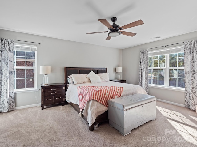 bedroom with light carpet, visible vents, and baseboards