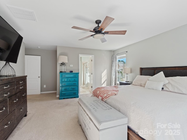 bedroom featuring visible vents, light carpet, ceiling fan, ensuite bath, and baseboards