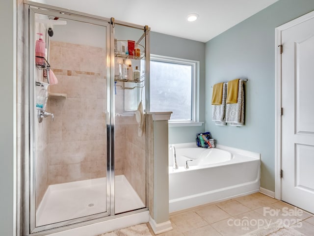 bathroom with a garden tub, tile patterned flooring, baseboards, and a shower stall