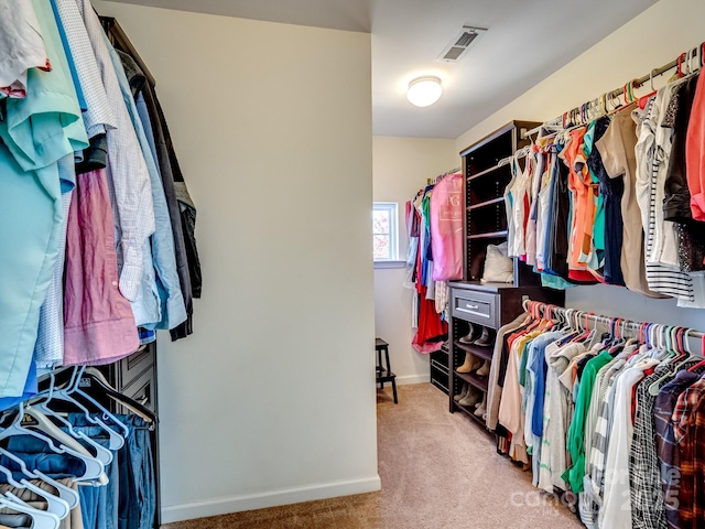 walk in closet with visible vents and light colored carpet