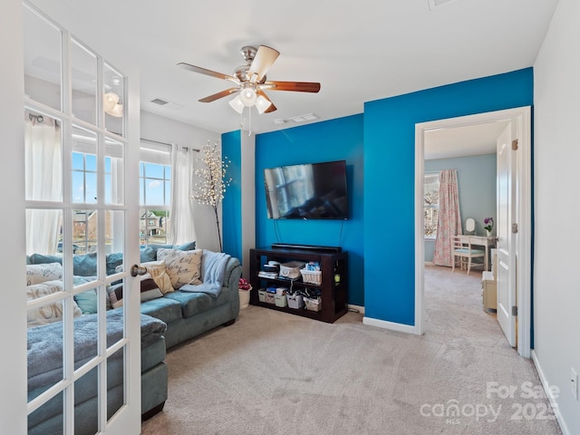 living area with carpet floors, french doors, visible vents, and baseboards