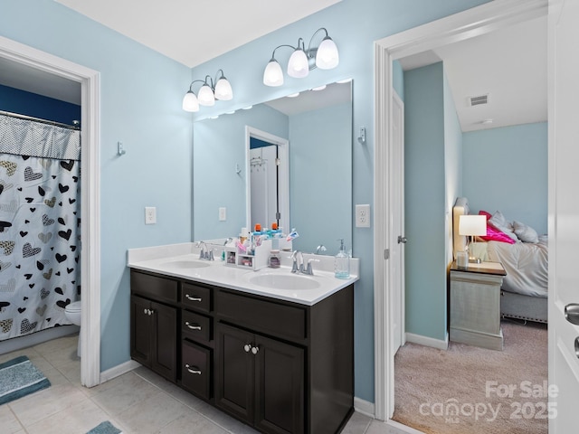 full bathroom with toilet, double vanity, a sink, and visible vents