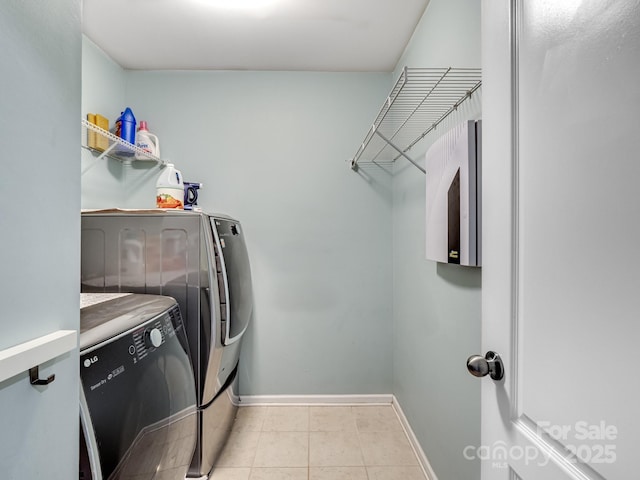 laundry area featuring laundry area, baseboards, separate washer and dryer, and light tile patterned flooring