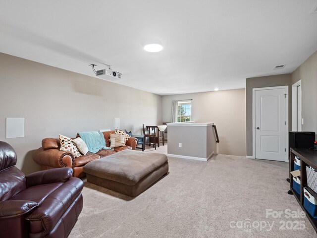 living room with carpet floors, visible vents, and baseboards