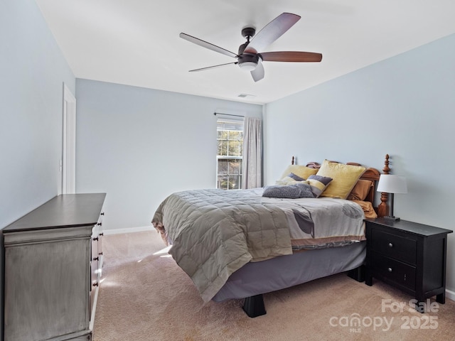 bedroom featuring baseboards, visible vents, ceiling fan, and light colored carpet