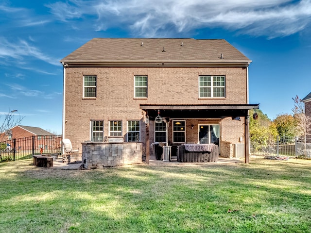 back of property with a yard, an outdoor fire pit, a fenced backyard, and a patio