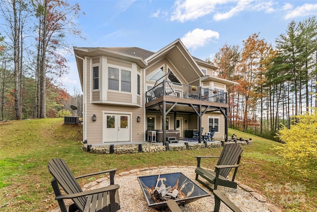 back of house featuring an outdoor fire pit, central AC, a hot tub, a wooden deck, and a patio area