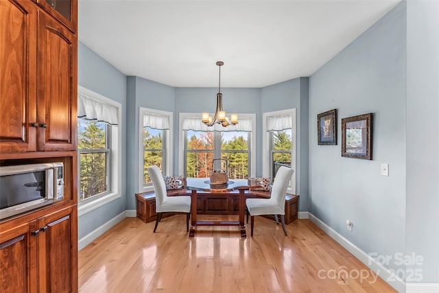 sitting room with light wood finished floors, baseboards, and a notable chandelier