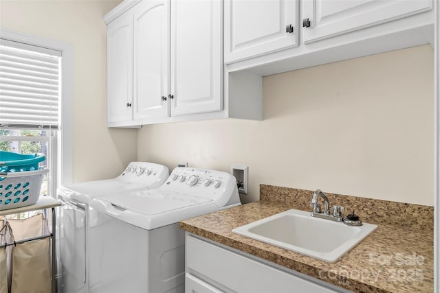 clothes washing area featuring cabinet space, a sink, and washing machine and clothes dryer