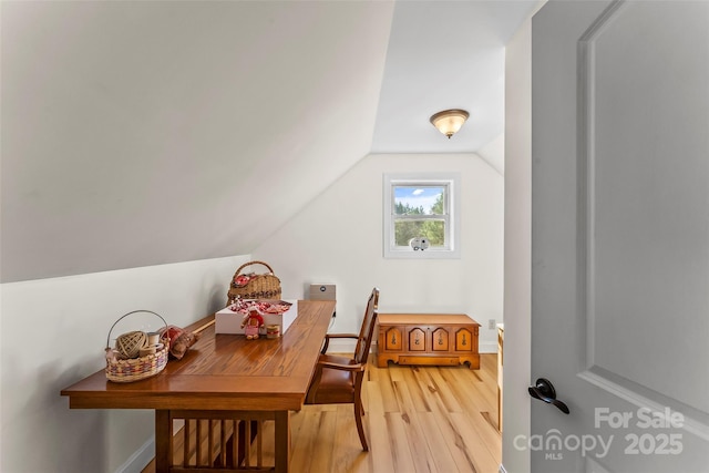 interior space with light wood-style floors, lofted ceiling, and baseboards