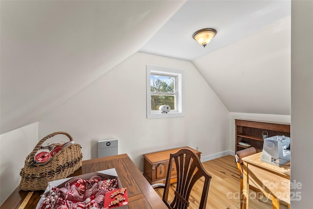 office area with light wood-type flooring, vaulted ceiling, and baseboards