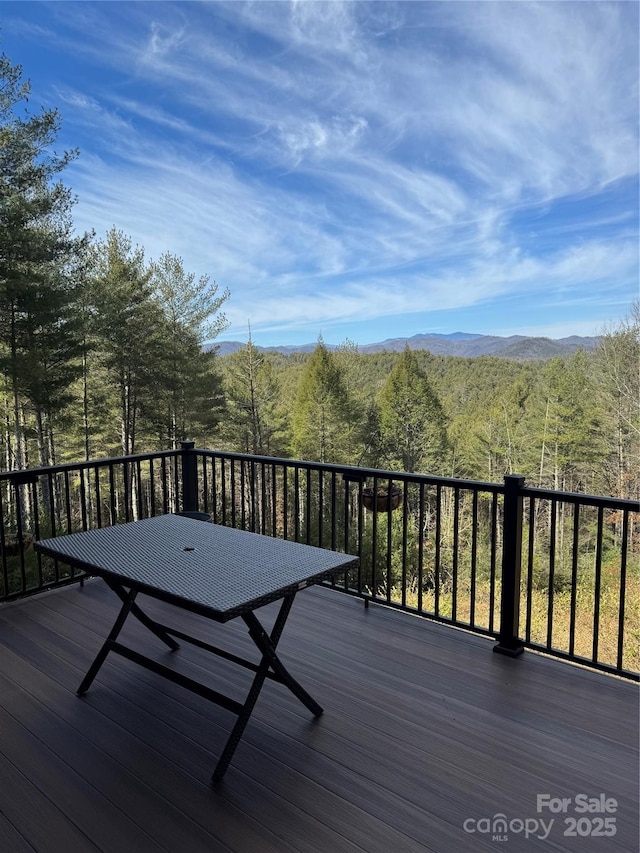 wooden deck with a forest view