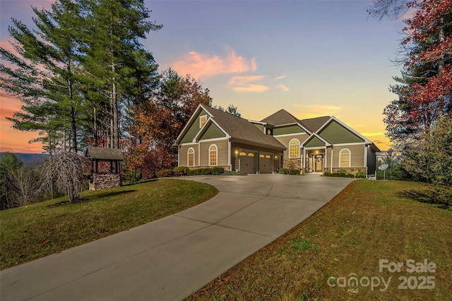 craftsman-style home featuring a garage, stone siding, concrete driveway, and a front yard