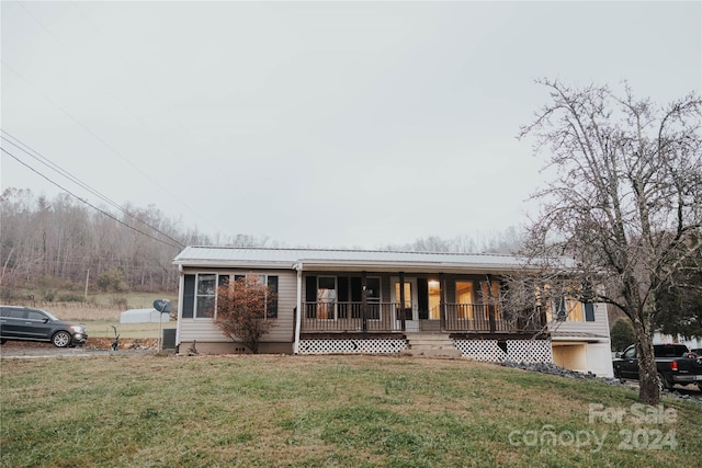 single story home featuring a porch and a front lawn