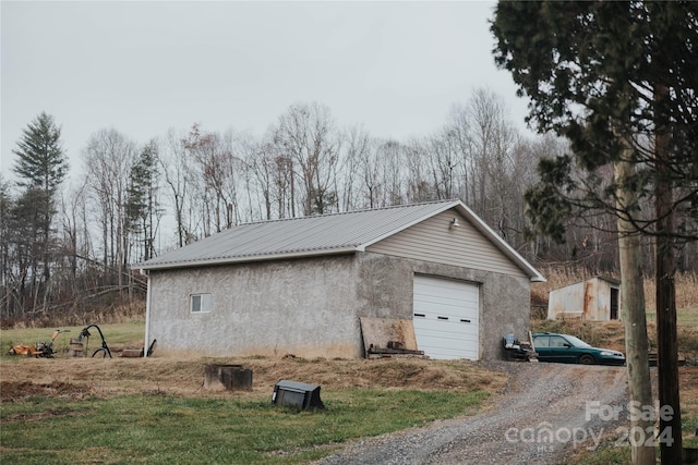 view of side of property with a garage and an outbuilding