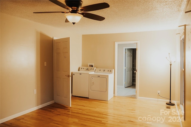 clothes washing area featuring washing machine and dryer, ceiling fan, a textured ceiling, and light wood-type flooring