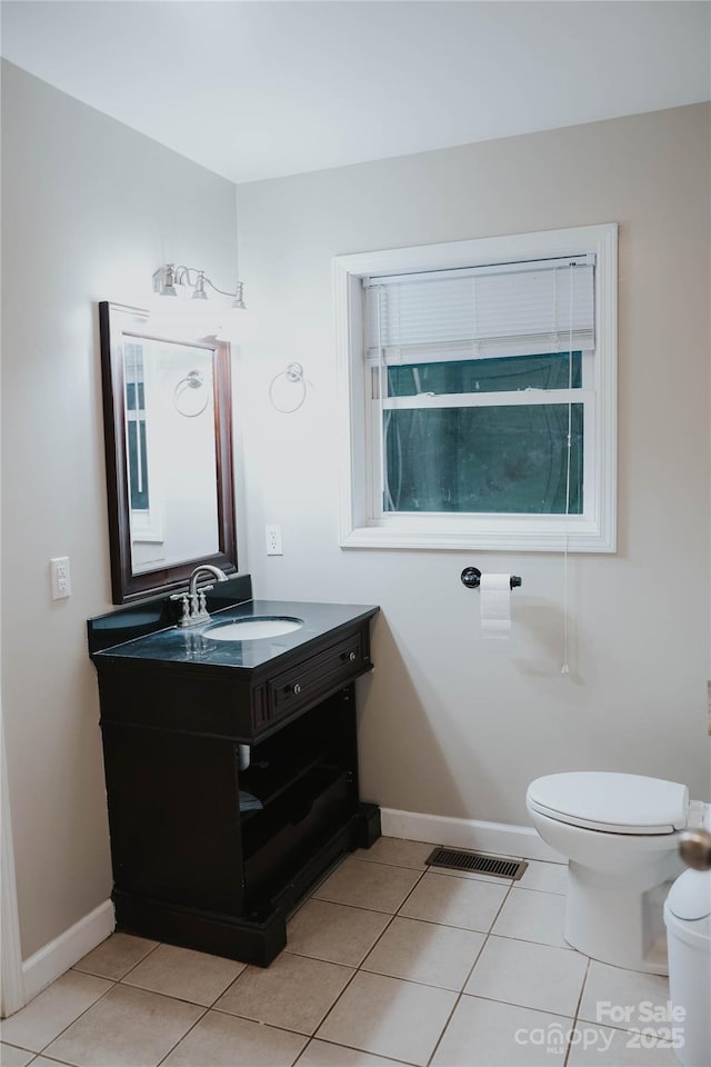half bathroom with baseboards, visible vents, toilet, and vanity
