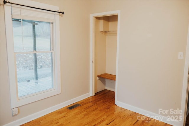 interior space featuring a closet, visible vents, light wood-style flooring, and baseboards