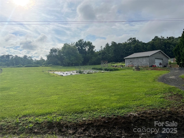 view of yard with a garage and a rural view
