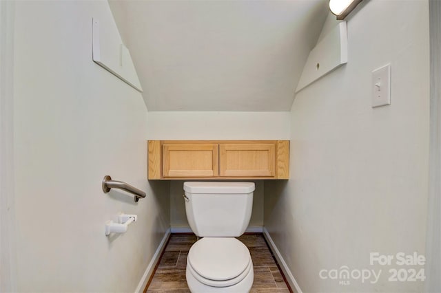 bathroom with hardwood / wood-style floors, vaulted ceiling, and toilet