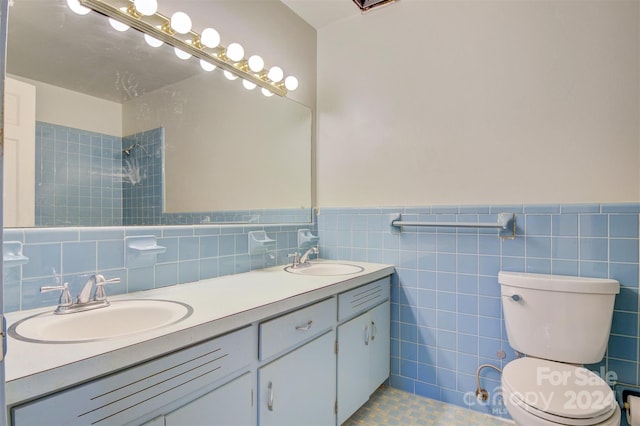 bathroom with tile patterned flooring, vanity, toilet, and tile walls