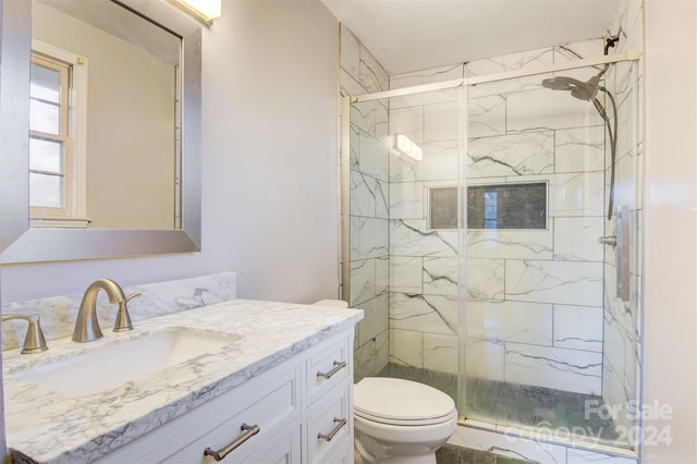 bathroom with walk in shower, vanity, and toilet