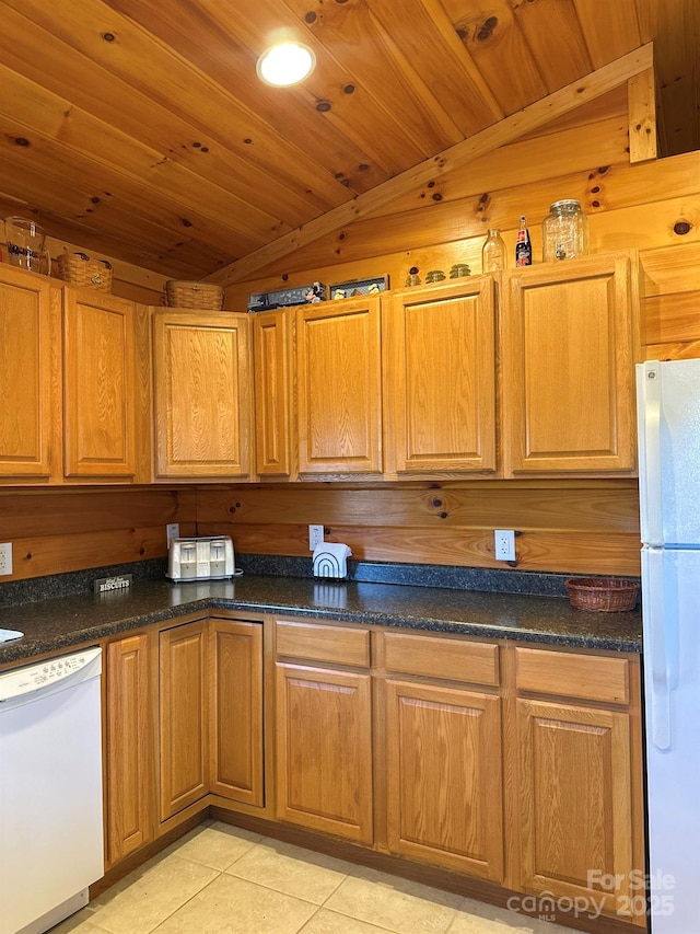 kitchen featuring dark countertops, wood ceiling, light tile patterned floors, brown cabinets, and white appliances