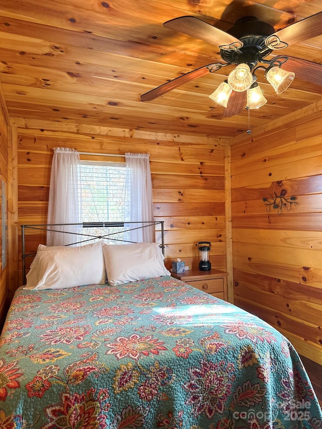 bedroom featuring wood walls, wood ceiling, and a ceiling fan