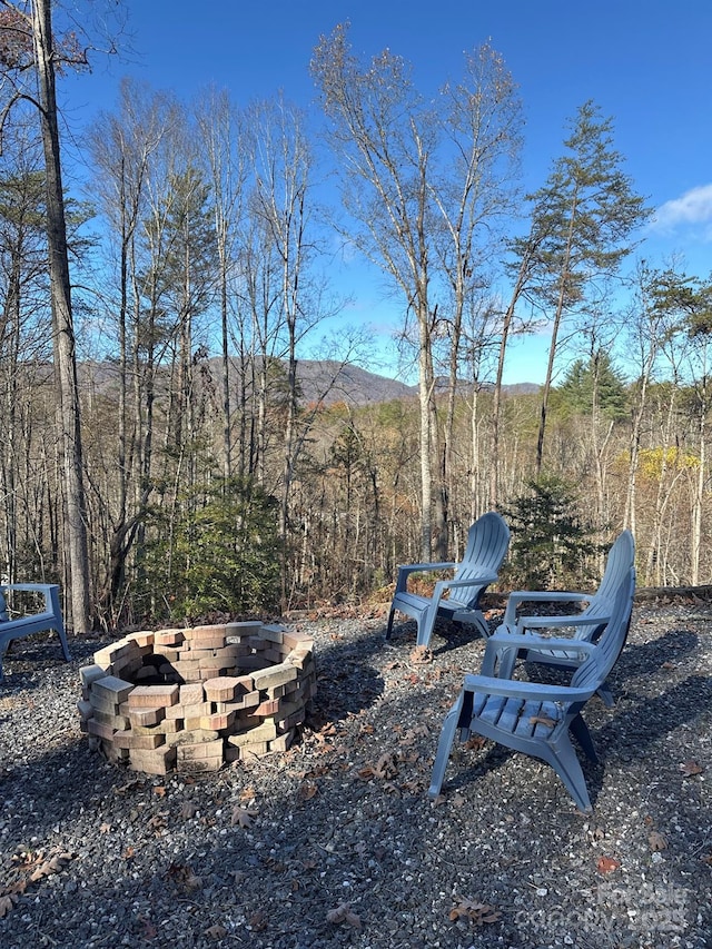 view of yard with a wooded view and a fire pit