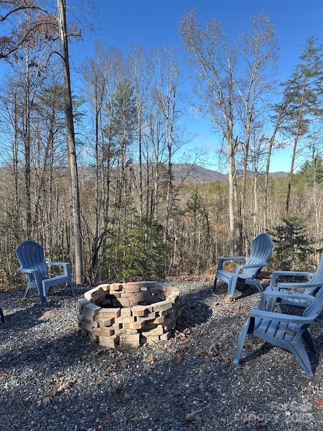 view of yard with a fire pit and a forest view