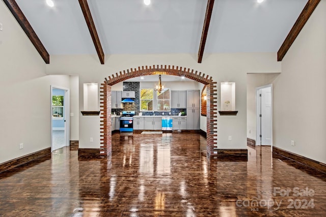 living room featuring an inviting chandelier and vaulted ceiling with beams