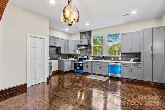 kitchen featuring gray cabinetry, appliances with stainless steel finishes, dark hardwood / wood-style floors, hanging light fixtures, and decorative backsplash