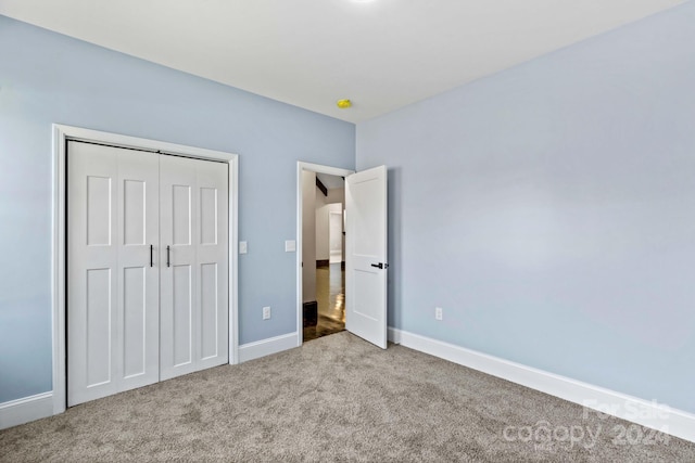 unfurnished bedroom featuring light carpet and a closet